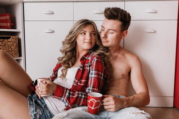 Young couple having coffee together at home in the kitchen. Enjoying nice morning together....
