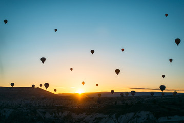 sunrise with hot air baloons in the air