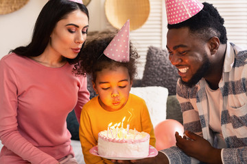 Family blowing out candles on a cake