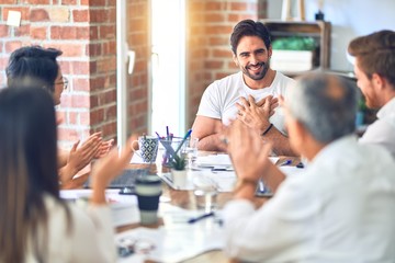Group of business workers smiling happy and confident. Working together with smile on face applauding one of them at the office