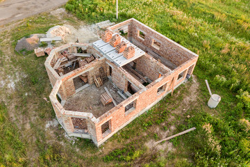 Aerial view of building site for future house, brick basement floor and stacks of brick for construction.