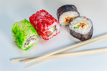 rolls with eel, tuna and salmon on a light glass surface