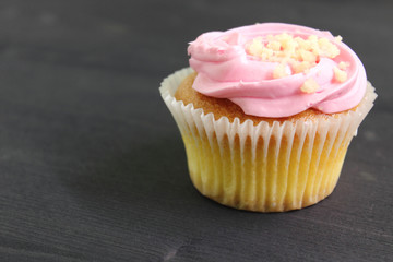 Chocolate muffin cake with cream and pink marshmallows decorated with chocolate on black background. 
