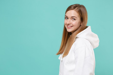Side view of pretty young woman girl in casual white hoodie posing isolated on blue turquoise background studio portrait. People sincere emotions lifestyle concept. Mock up copy space. Looking camera.