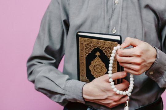 Guy holds Quran and Islamic rosary