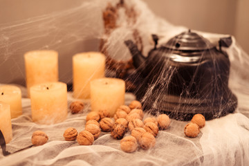 Obraz na płótnie Canvas Black teapot with nuts and candles in spider halloween
