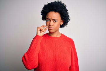 Young beautiful African American afro woman with curly hair wearing red casual sweater mouth and...