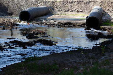 Pipe from which toxic waste spills into the river