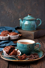 Chocolate muffins with  cup of tea  on  wooden  table