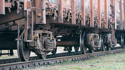 Naklejka premium Old rusty wagons on flights. Side view, selective focus.