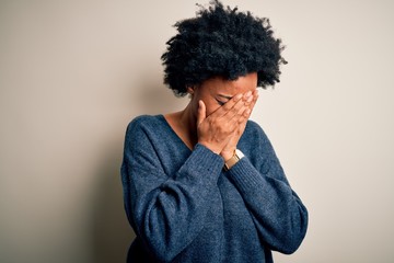 Obraz na płótnie Canvas Young beautiful African American afro woman with curly hair wearing casual sweater with sad expression covering face with hands while crying. Depression concept.