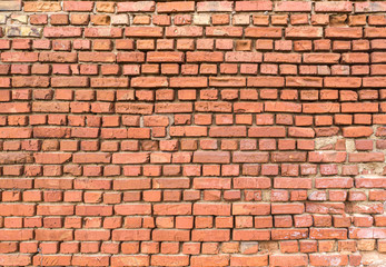 Red brick wall partially destroyed by rain. Texture.