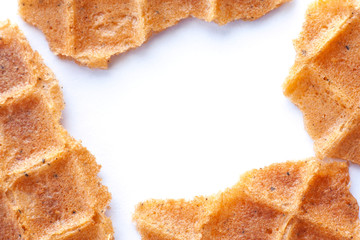 Frame of broken wafer slices on white background. Macro photo of waffle texture. Relief surface of waffle with spices close-up. Baking background. Copy space.