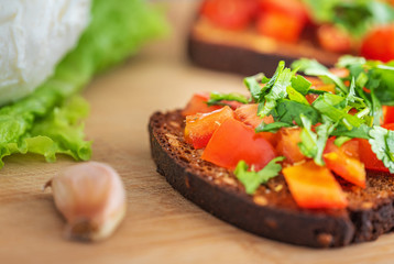 close up view to garlic and bruschetta with red tomatoes and green сшдфтекщ