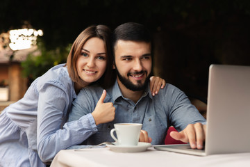 Work online. Happy man and woman working from home, young couple with cup of coffee working on laptop indoors