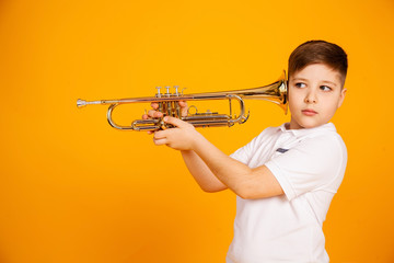 The boy overhears through the pipe. I want to hear everything. Handsome curious boy in a white...