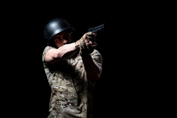 Fototapeta na wymiar Military Man Holding Gun Isolated on Black Background