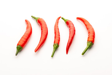 Red chili peppers on a white background. Isolate. Hot peppers. A few fresh pods of red pepper.