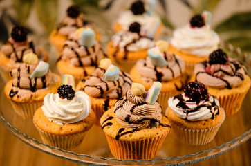 colorful cream decorated cupcakes. coffee with milk and cup cakes. blacl coffee glass and black cake plate 