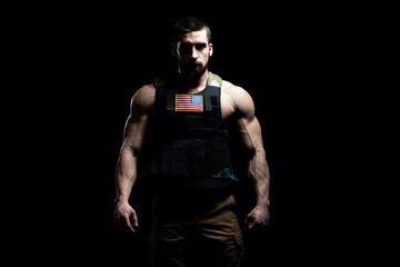 Obraz na płótnie Canvas Bodybuilder Soldier With Bulletproof Vest on Black Background