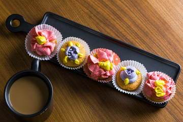 cup cake decorated with marshmallows, blackberries and red raspberries on a glass cake plate