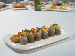 Seafood. Fish cakes and cheese rolls stuffed with fish fillet on a plate on a white background