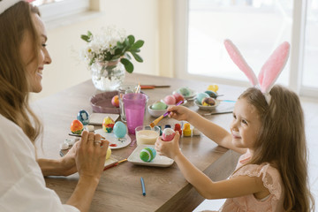 happy family enjoing time together while decorate easter eggs.