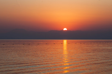 Red sunset at sea over the mountains. Turkey. Horizontal photo.