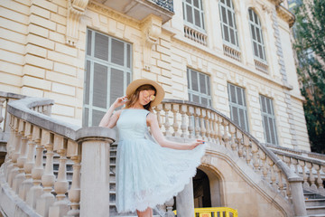 A young girl in a blue dress walks through the city of Barcelona