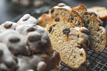 A close-up of sliced Christmas Stollen, traditional German cake, dusted with powdered sugar, with raisins and almonds