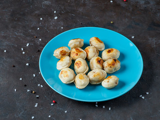 Russian pelmeni on the blue plate.