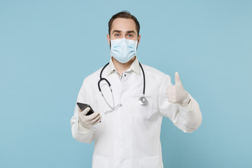 Male on-line doctor man in medical gown sterile face mask gloves isolated on blue background....