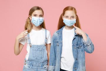 Two little kids girls 12-13 years old isolated on pink background children portrait. Epidemic...