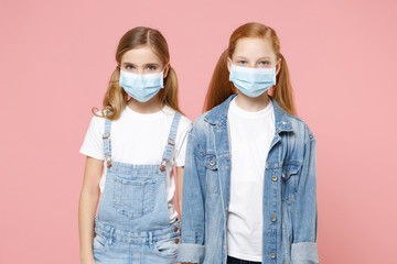 Two little kids girls 12-13 years old in sterile face mask isolated on pink wall background children portrait. Epidemic pandemic coronavirus 2019-ncov sars covid-19 flu virus concept. Looking camera.