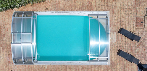 View of the pool with a roof from the rain from the air, shooting from a drone.