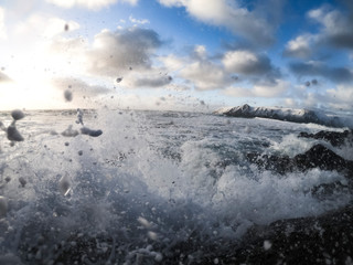 wave crashing with island in the background