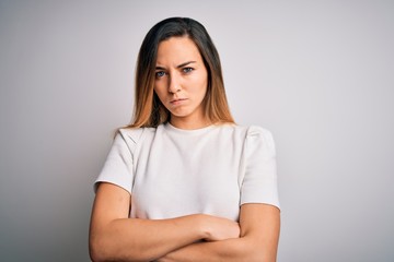 Fototapeta premium Young beautiful blonde woman with blue eyes wearing casual t-shirt over white background skeptic and nervous, disapproving expression on face with crossed arms. Negative person.