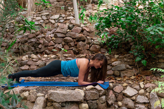 Young woman practicing yoga in the parck