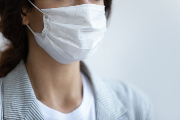 Close up focus on respiratory protective medical mask on female face. Young woman wearing facial mask, protecting breath from air pollution, world virus outbreak spread public healthcare awareness.