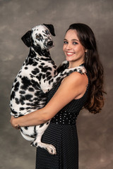 mulher com dálmata no colo em casa