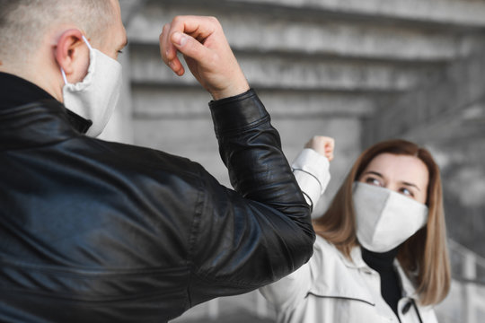 Elbow bumping. A new way of greeting to avoid the spread of coronavirus, covid19. Man and a woman bump elbows instead of hug or handshake