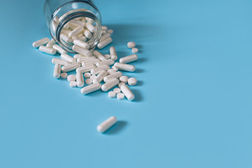 White medical pills on blue background. 