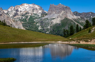 Fototapeta na wymiar Mont Thabor and Le Grand Seru are reflected in the Lake Chavillon on Etroite Valley in Hautes-Alpes, France.
