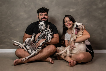 casal feliz em casa com cachorros no colo família