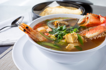 A view of a bowl of seafood soup, in a restaurant or kitchen setting.