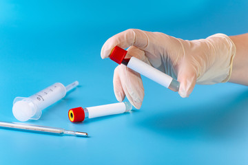 The doctor holds a test tube with a blood test to detect the coronavirus. A new concept of virus COVID-19 embraced the whole world.