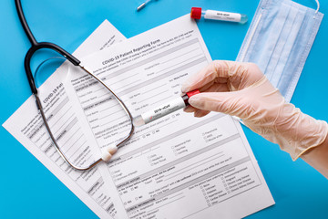 The doctor holds a test tube with a blood test to detect the coronavirus. A new concept of virus COVID-19 embraced the whole world.