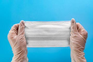 Protective medical face mask in the hands of a medic. Mask for protection against influenza,...