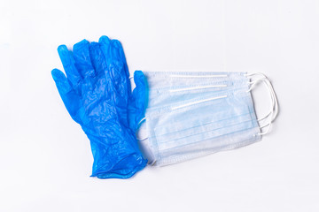 Thin blue medical gloves and protective face masks on a blue background. Disposable gloves and masks for protection against covid-19 virus