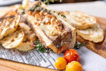 A closeup view of a dish of bone marrow, in a restaurant or kitchen setting.